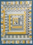 Yellow and gray baby quilt made from fabric scraps
